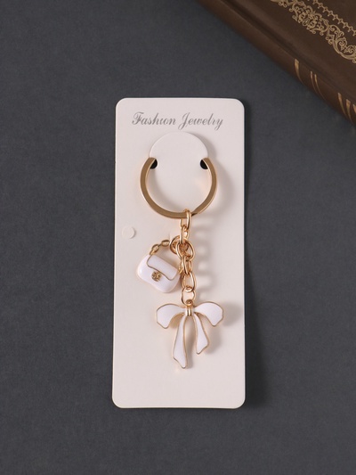 Брелок металл, эмаль "Сумочка и бант" белый 9 см